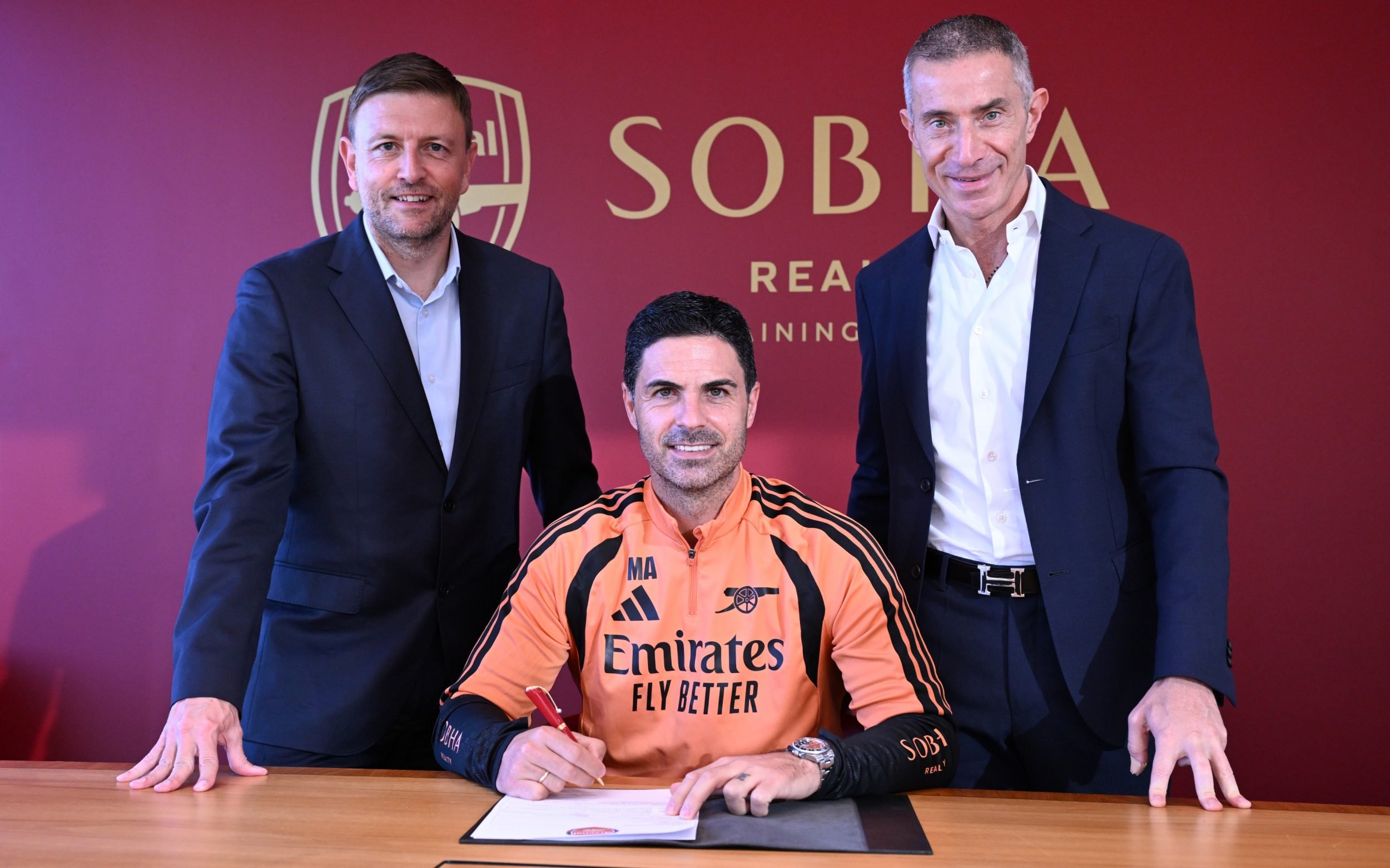 Mikel Arteta signing his new contract alongside Richard Garlick