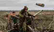 A Ukrainian serviceman of an artillery unit throws an empty shell as they fire towards Russian positions on the outskirts of Bakhmut, eastern Ukraine