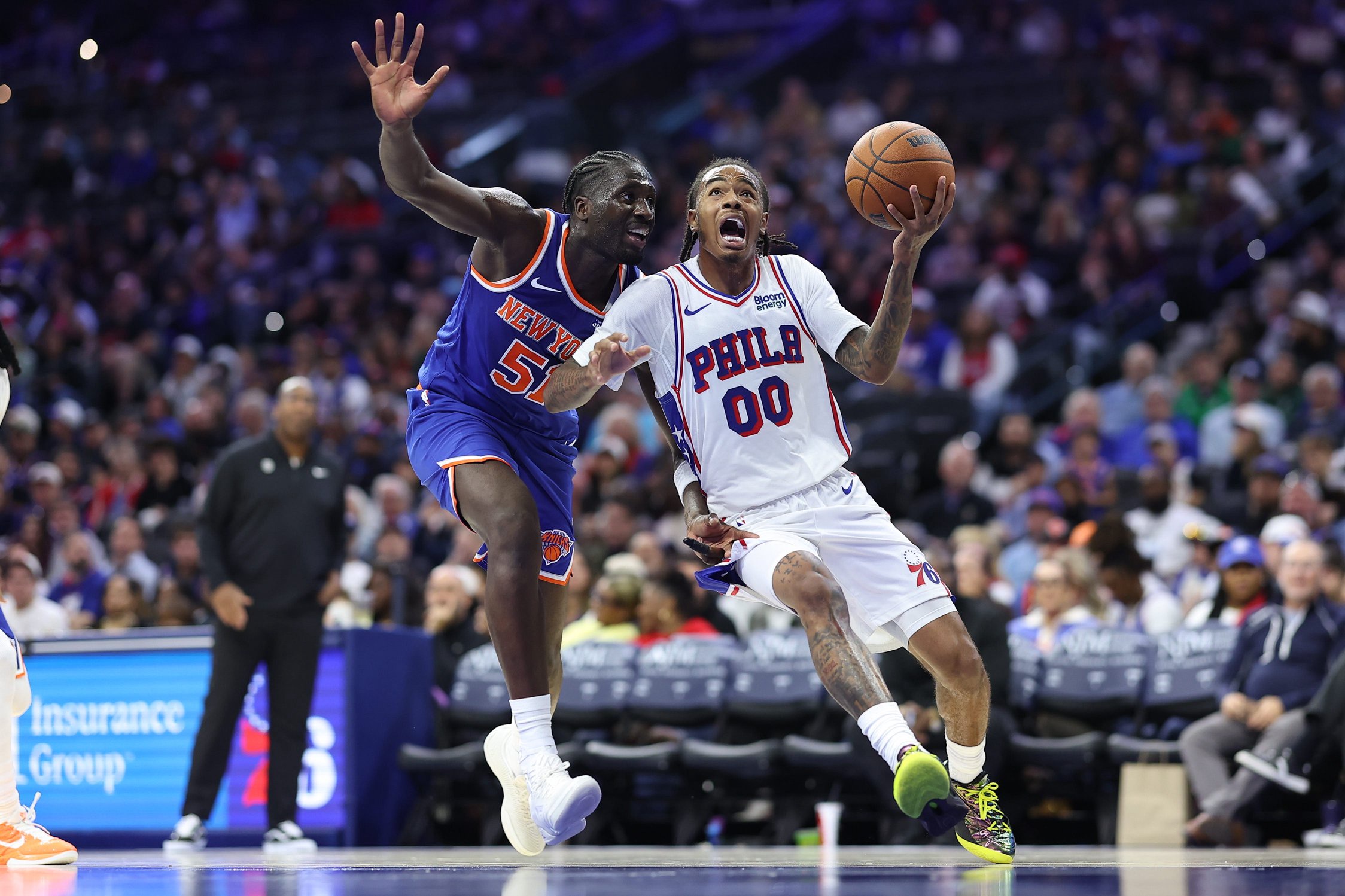 Oct 5, 2026; Philadelphia, Pennsylvania, USA; Philadelphia 76ers guard Labaron Philon Jr. (00) drives against New York Knicks forward Mohamed Diawara (51) during the third quarter at Xfinity Mobile Arena. Mandatory Credit: Bill Streicher-Imagn Images