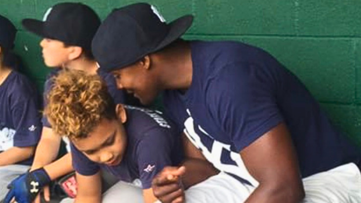 teen boy baseball player in the dugout with coach