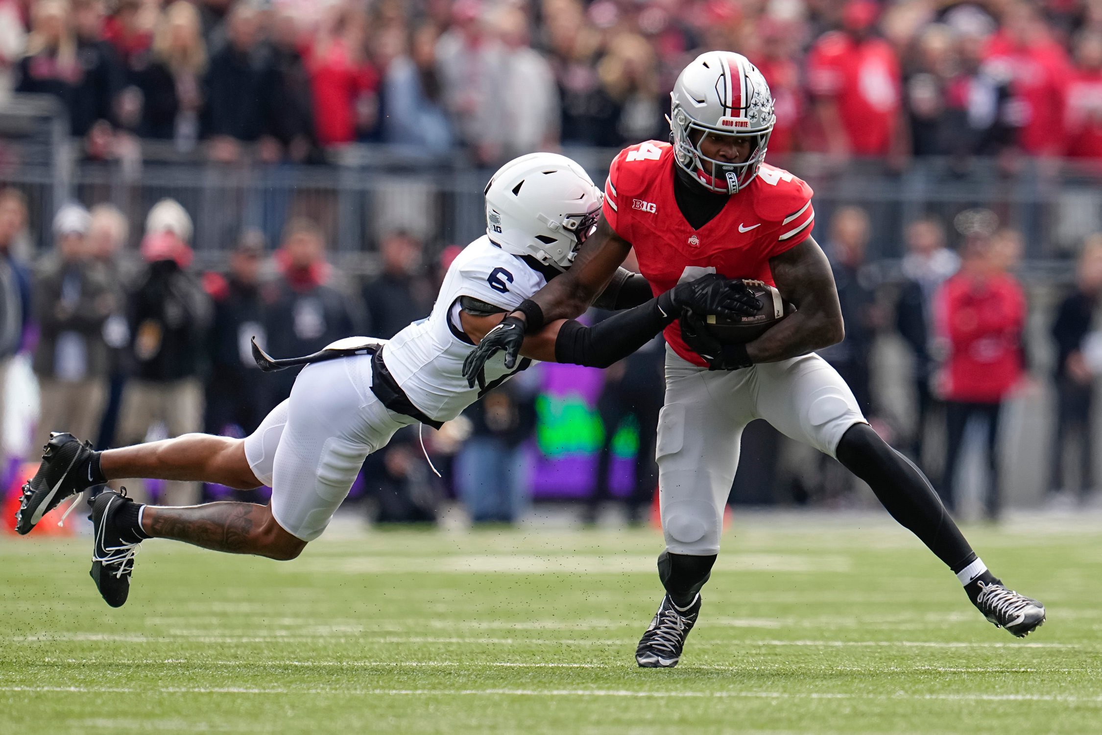 Ohio State Buckeyes wide receiver Jeremiah Smith (4) catches a pass in front of Penn State Nittany Lions safety Zakee Wheatley (6) during the NCAA football game at Ohio Stadium in Columbus on Nov. 1, 2025.