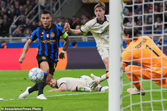 Inter Milan's Lautaro Martinez, left, scores his side's opening goal during the Champions League opening phase soccer match between Inter Milan and Club Brugge in Milan, Italy, Tuesday, Oct. 13, 2026. (AP Photo/Luca Bruno)