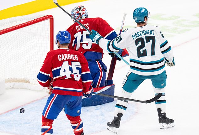 San Jose Sharks' Mason Marchment (27) celebrates as Montreal Canadiens goaltender Jakub Dobes (75) and Alexandre Carrier (45) look back at the puck following a goal by Sharks' Macklin Celebrini during overtime in an NHL hockey game in Montreal, Tuesday, Oct. 20, 2026. (Christinne Muschi/The Canadian Press via AP)