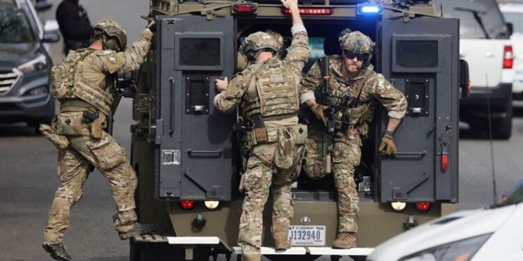 An FBI tactical team deploys from an armored vehicle at the scene of a reported shooting and active shooter near Edmund Burke Middle School in the Cleveland Park neighborhood of Northwest Washington, U.S., April 22, 2022.