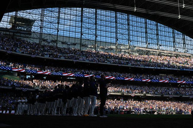 The Milwaukee Brewers stand for the anthem prior to Game 2 of baseball's National League Championship Series between the Milwaukee Brewers and the Los Angeles Dodgers, Monday, Oct. 12, 2026, in Milwaukee. (AP Photo/Ashley Landis)