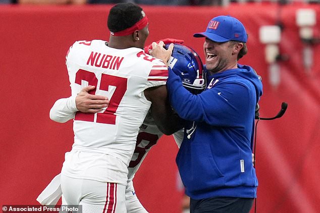 New York Giants head coach John Harbaugh, right, celebrates with safety Tyler Nubin (27), and quarterback J.J. McCarthy, center, following an overtime win over the Houston Texans in an NFL football game in Houston, Sunday, Oct. 25, 2026. (AP Photo/Eric Smith)