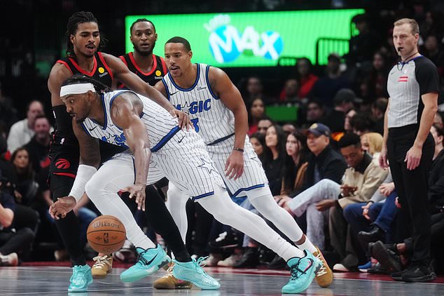Orlando Magic's Wendell Carter Jr., front, drives past Toronto Raptors' Collin Murray-Boyles, top left, during the first half of an NBA Cup basketball game in Toronto, Friday, Oct. 30, 2026. (Nathan Denette/The Canadian Press via AP)