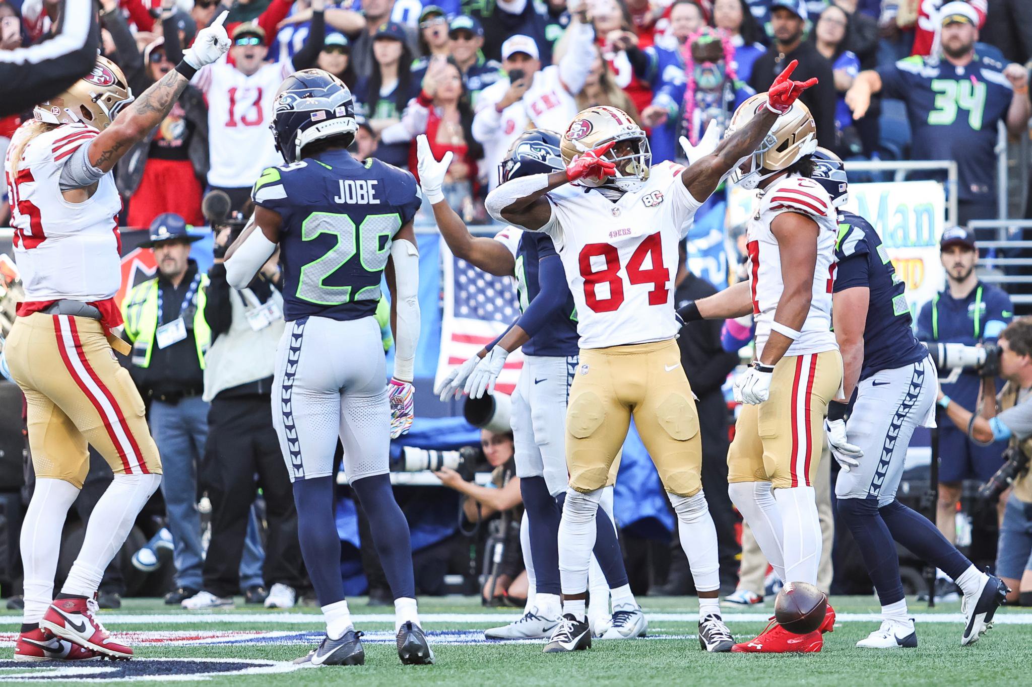 San Francisco 49ers wide receiver Jacob Cowing (84) celebrates on the field with teammates after a play against the Seattle Seahawks.