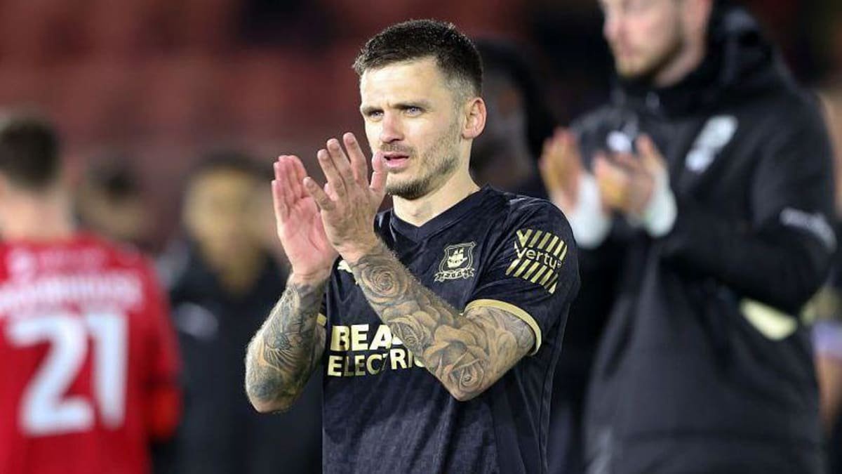 Jamie Paterson, in Plymouth Argyle's change black-and-gold strip, applauds during a match