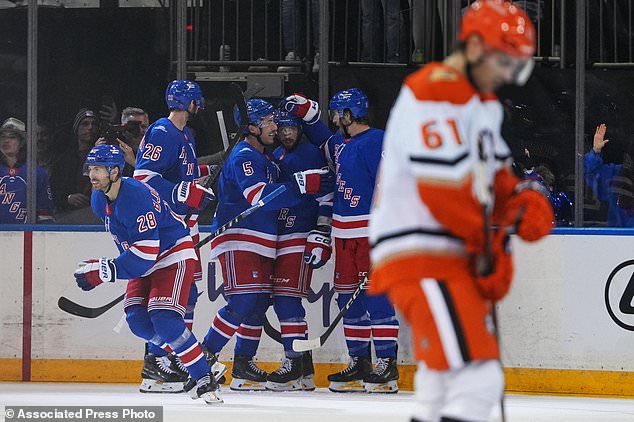 New York Rangers' Oliver Bjorkstrand (28) celebrates with teammates after scoring a goal as Anaheim Ducks' Cutter Gauthier (61) skates away during the second period of an NHL hockey game Monday, Oct. 19, 2026, in New York. (AP Photo/Frank Franklin II)