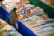 A woman looks at a huge stall selling books.