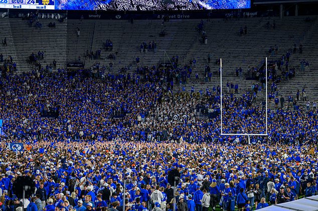 BYU fans storm the field after beating Notre Dame in an NCAA college football game, Saturday, Oct. 17, 2026, in Provo, Utah. (AP Photo/Tyler Tate)