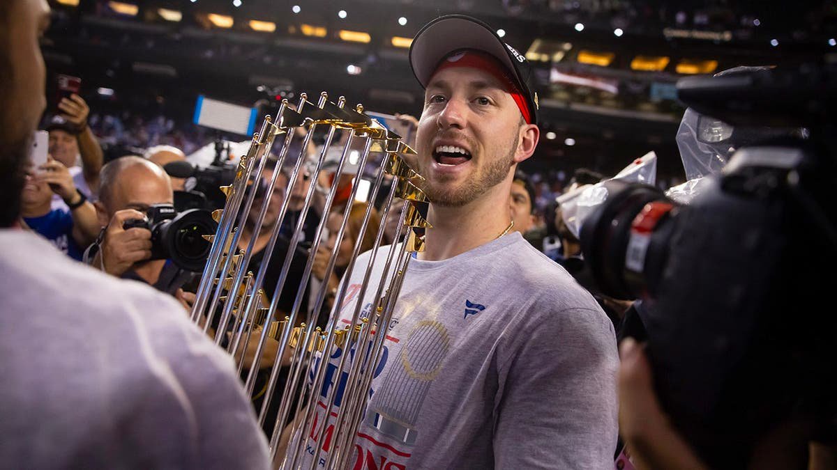 Mitch Garver celebrates with the World Series trophy after the Rangers defeated the Diamondbacks.