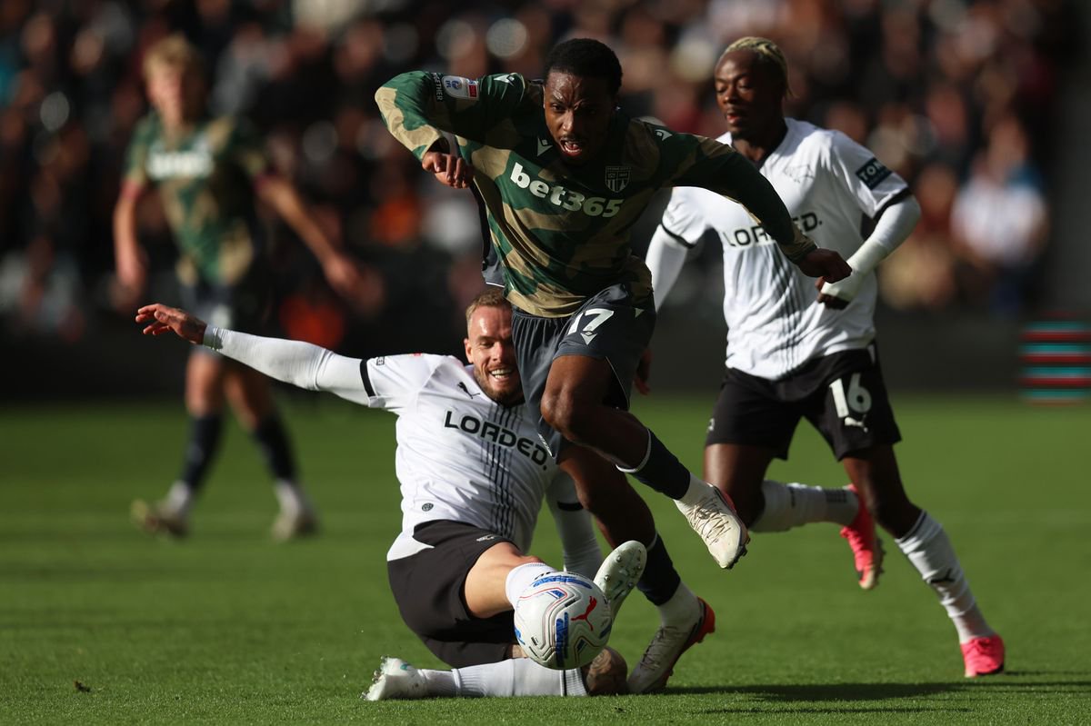 Eric Bocat of Stoke City is tackled by Joe Ward of Derby County