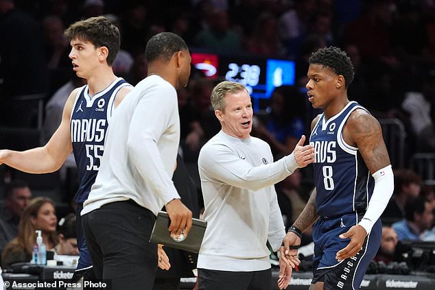 Dallas Mavericks head coach Dusty May, center, talks with guard Marcus Sasser (8) as he leaves the court during the first half of an NBA basketball game against the Miami Heat, Monday, Oct. 26, 2026, in Miami. (AP Photo/Rebecca Blackwell)