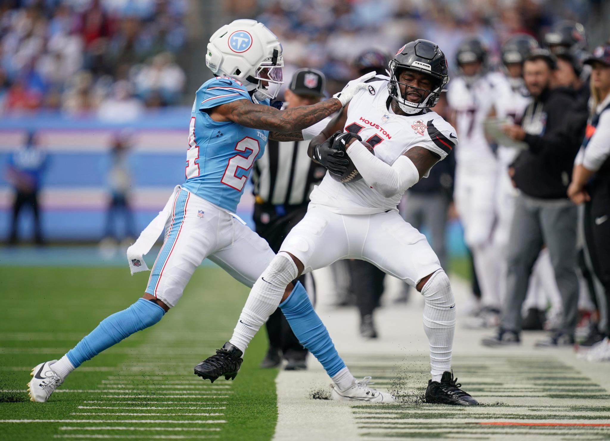 Tennessee Titans cornerback Alontae Taylor pushes Houston Texans wide receiver Kayshon Boutte out of bounds.