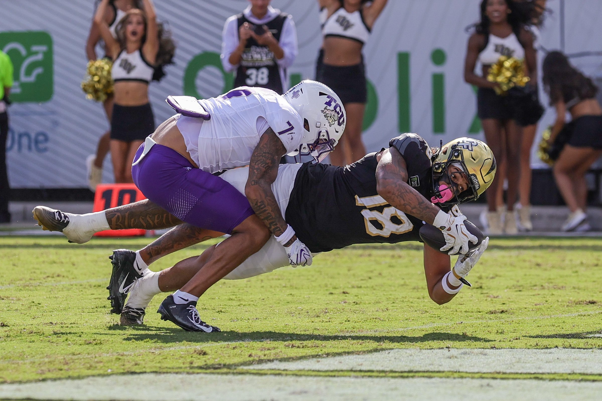 Sep 26, 2026; Orlando, Florida, USA;  UCF Knights tight end Caden Piening (18) scores against TCU Horned Frogs safety Julius Simms (7) during the second quarter at Acrisure Bounce House.  Mandatory Credit: Mike Watters-Imagn Images