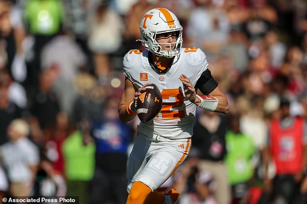 Tennessee quarterback George MacIntyre (12) rolls out to pass during the first half of an NCAA college football game against South Carolina, Saturday, Oct. 24, 2026, in Columbia, S.C. (AP Photo/Artie Walker Jr.)