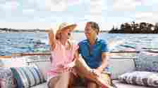 Laughing, happy couple and on a boat for retirement travel, summer freedom and holiday in Bali. Smile, love and a senior man and woman on a yacht for vacation adventure, luxury and a cruise date