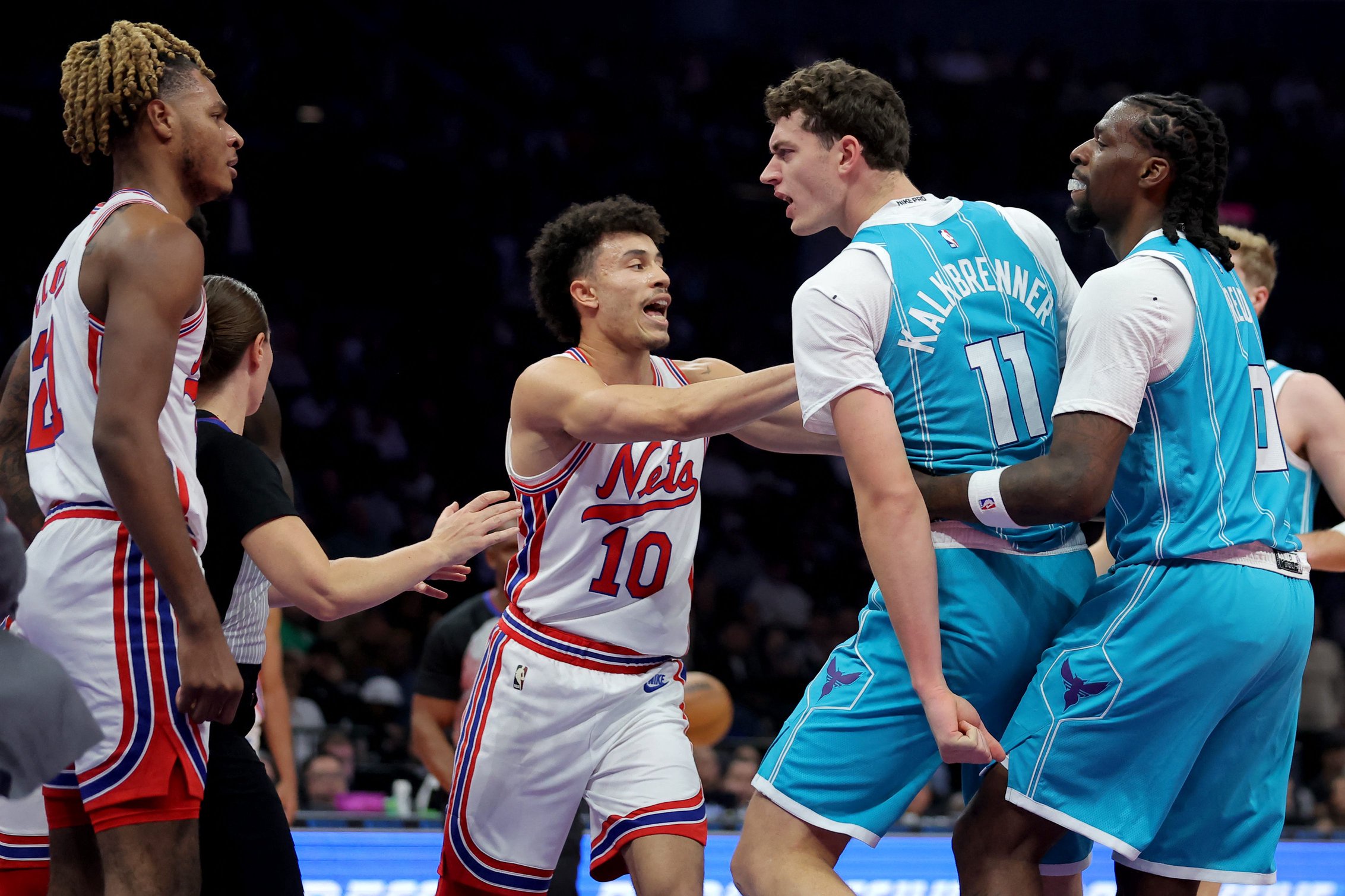 Oct 21, 2026; Brooklyn, New York, USA; Charlotte Hornets center Ryan Kalkbrenner (11) is held back from Brooklyn Nets forward Noah Clowney (21) by Hornets center Naz Reid (0) and Nets guard Nolan Traore (10) during the second quarter at Barclays Center. Mandatory Credit: Brad Penner-Imagn Images