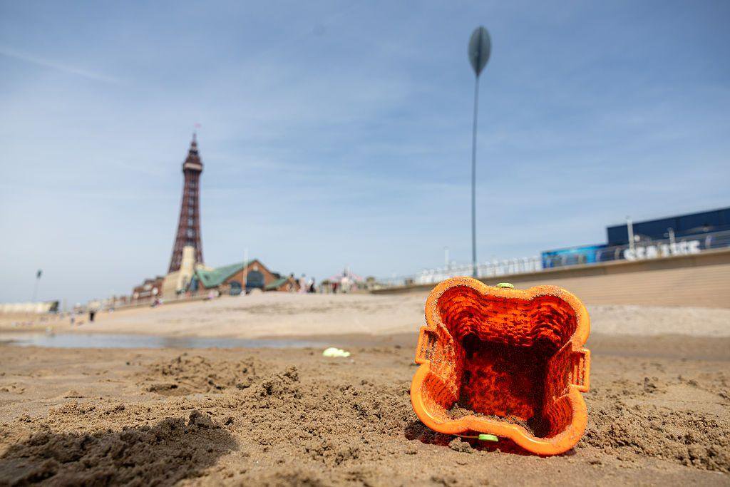 A picture of a bucket on Blackpool beach, with the Blackpool tower in the background
