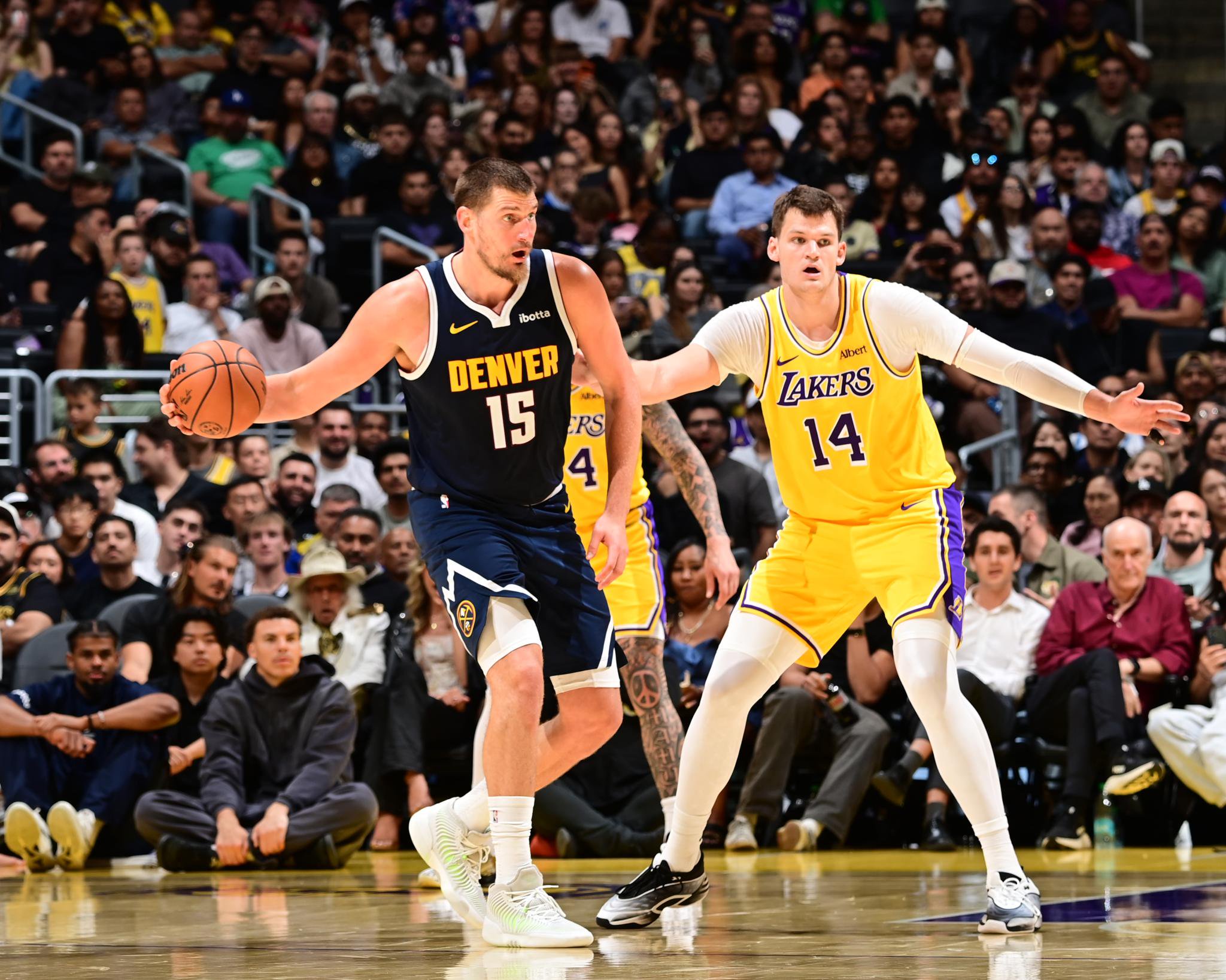 Walker Kessler of the Los Angeles Lakers plays defense on Nikola Jokic of the Denver Nuggets during a game.