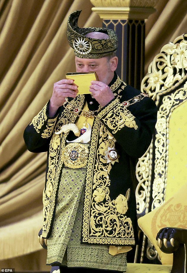 The King of Malaysia, Sultan Ibrahim Iskandar, kisses a copy of the Koran