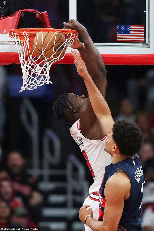 Chicago Bulls forward Caleb Wilson, back, dunks against Washington Wizards forward Kyshawn George, front, during the second quarter of an NBA basketball game, Saturday, Oct. 24, 2026, in Chicago. (AP Photo/Jessie Alcheh)