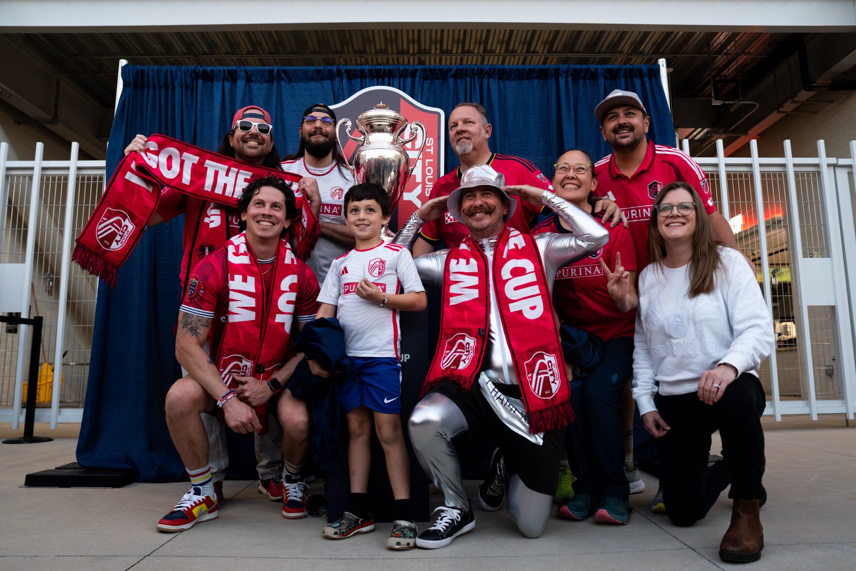 Chris Powers, of Maplewood, center right, dressed as the Lamar Hunt U.S. Open Cup trophy, poses for a photo alongside fellow St. Louis City SC supporters on Wednesday, Oct. 28, 2026, in St. Louis’ Downtown West neighborhood.