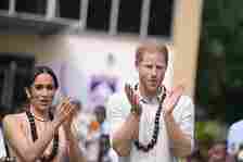 Harry and Meghan clap as they meet children at the Wuse Lightway Academy in Abuja today
