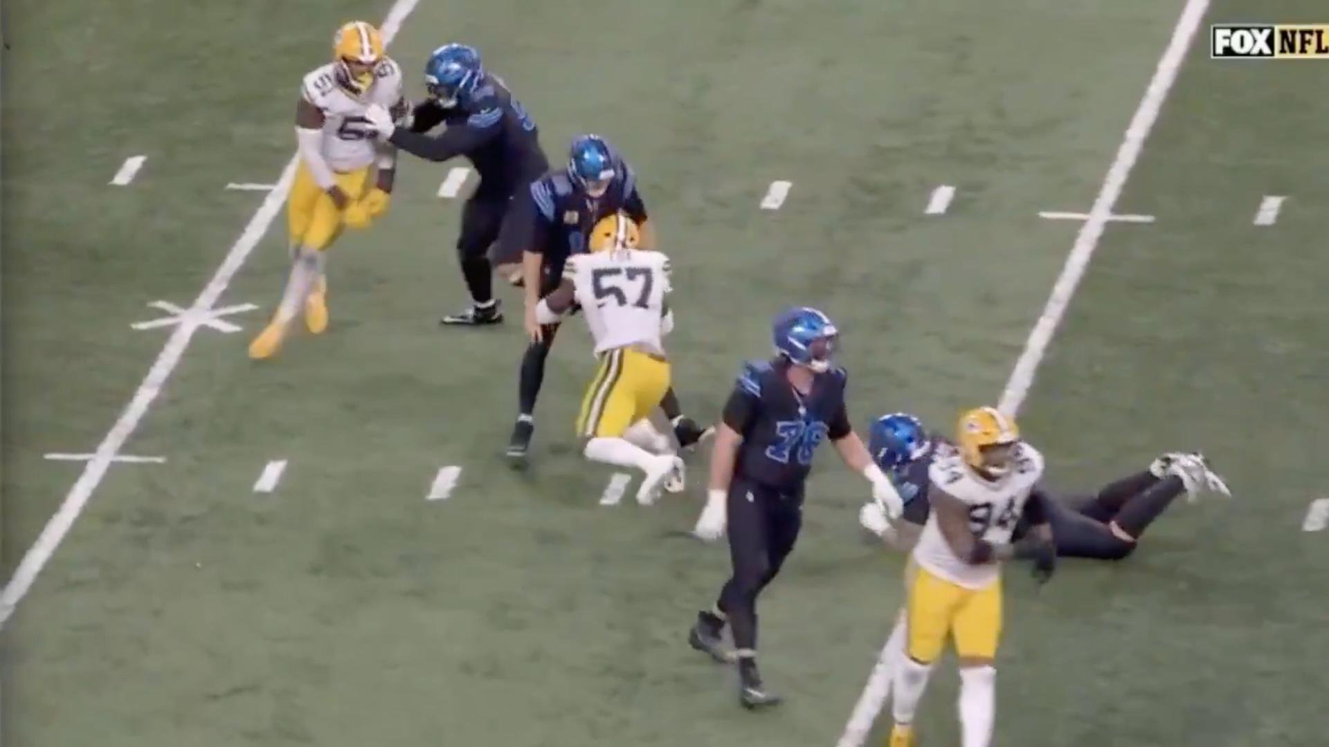 Football players in green and yellow and blue and black uniforms during a game.