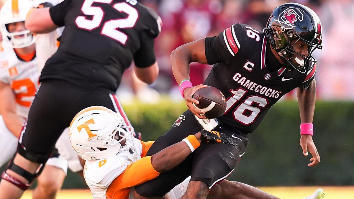 LaNorris Sellers escapes a tackle attempt by Qua Moss during a college football game.