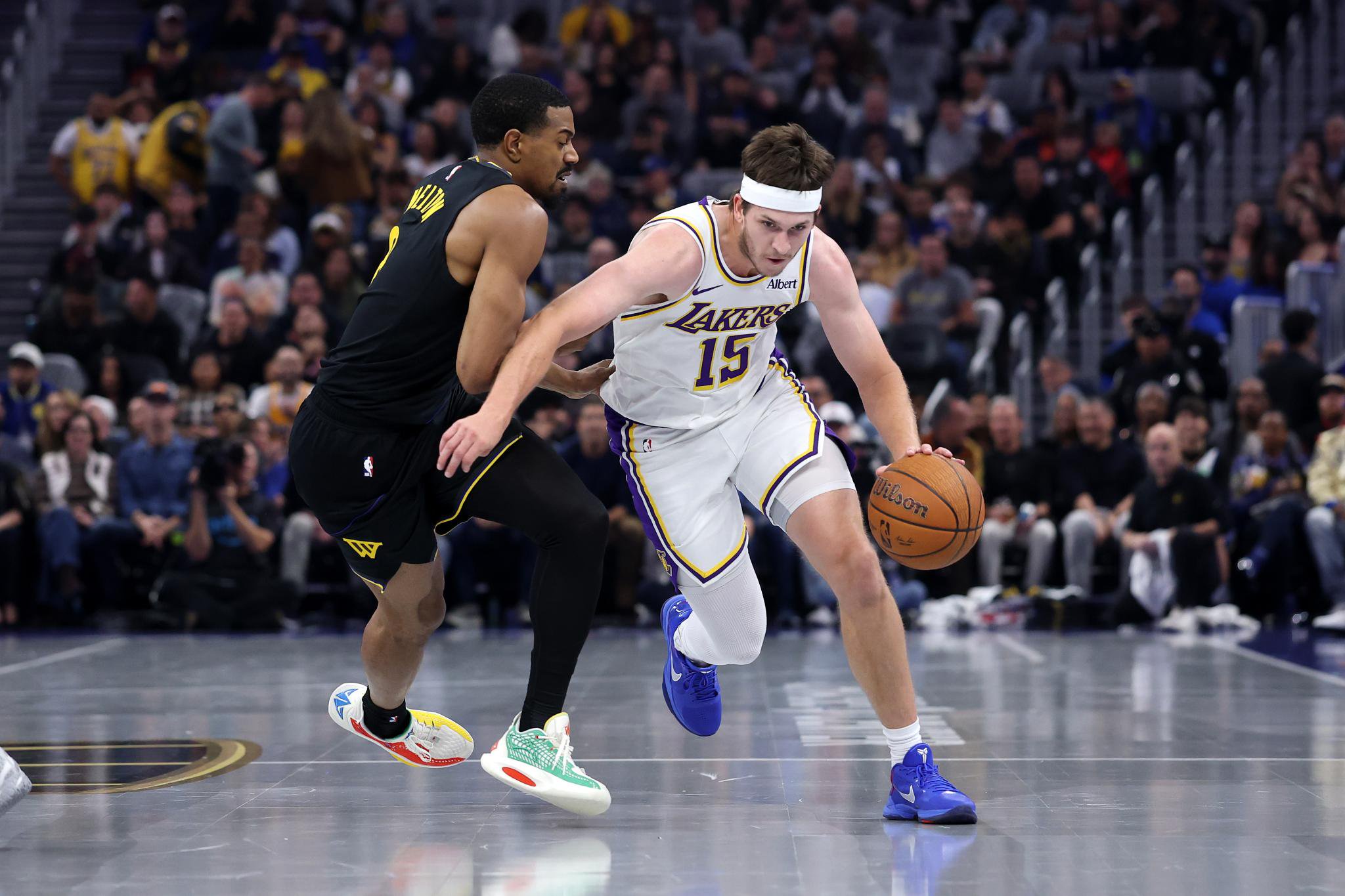 Austin Reaves of the Los Angeles Lakers dribbles the ball while guarded by De'Anthony Melton of the Golden State Warriors.
