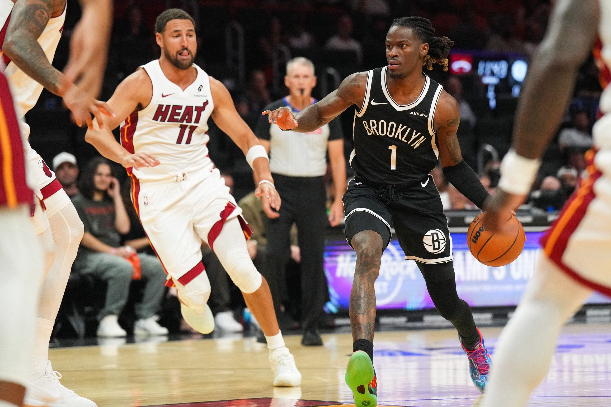 Oct 14, 2026; Miami, Florida, USA;  Brooklyn Nets guard Keon Ellis (1) drives to the basket as Miami Heat guard Klay Thompson (11) closes in during the first half at Kaseya Center.  Mandatory Credit: Jim Rassol-Imagn Images