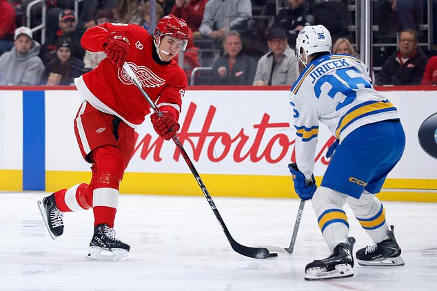 Detroit Red Wings center Emmitt Finnie (58) takes a shot on goal as St. Louis Blues defenseman Adam Jiricek (36) defends during the first period of an NHL hockey game Saturday, Oct. 31, 2026, in Detroit. (AP Photo/Duane Burleson)
