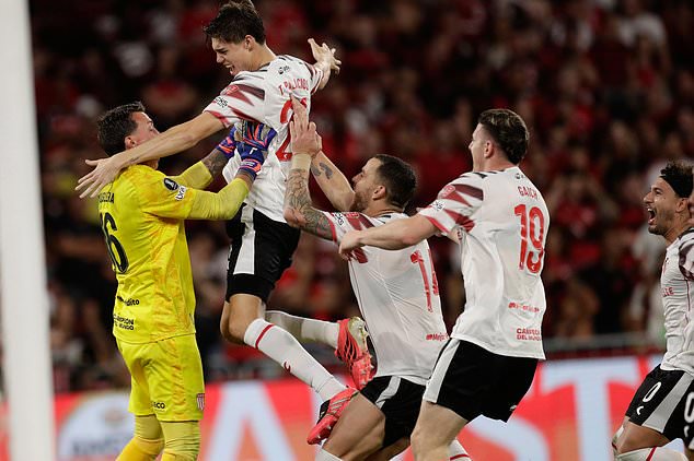 Players of Argentina's Estudiantes de La Plata celebrate with goalkeeper Nestor Muslera after winning a penalty shootout against Brazil's Flamengo during the second leg of a Copa Libertadores semifinal soccer match in Rio de Janeiro, Thursday, Oct. 22, 2026. (AP Photo/Bruna Prado)