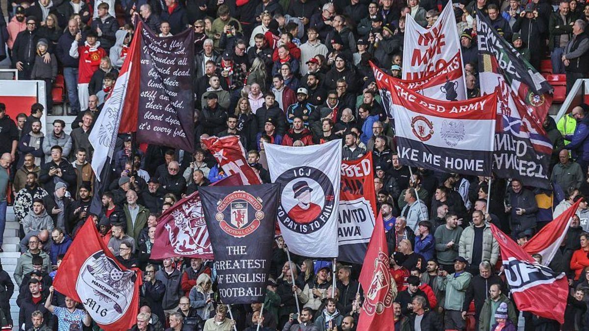 Manchester United fans hold up flags before the Premier League match between Manchester United and Tottenham Hotspur at Old Trafford.
