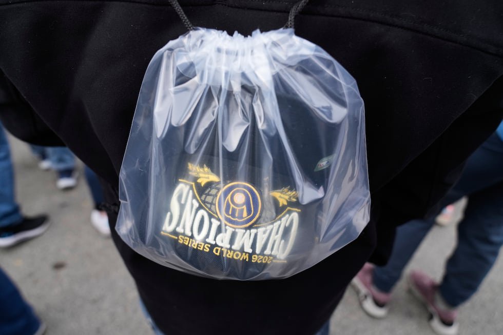 A fan arrives with a Milwaukee Brewers' Champions hat during the baseball team's World Series...