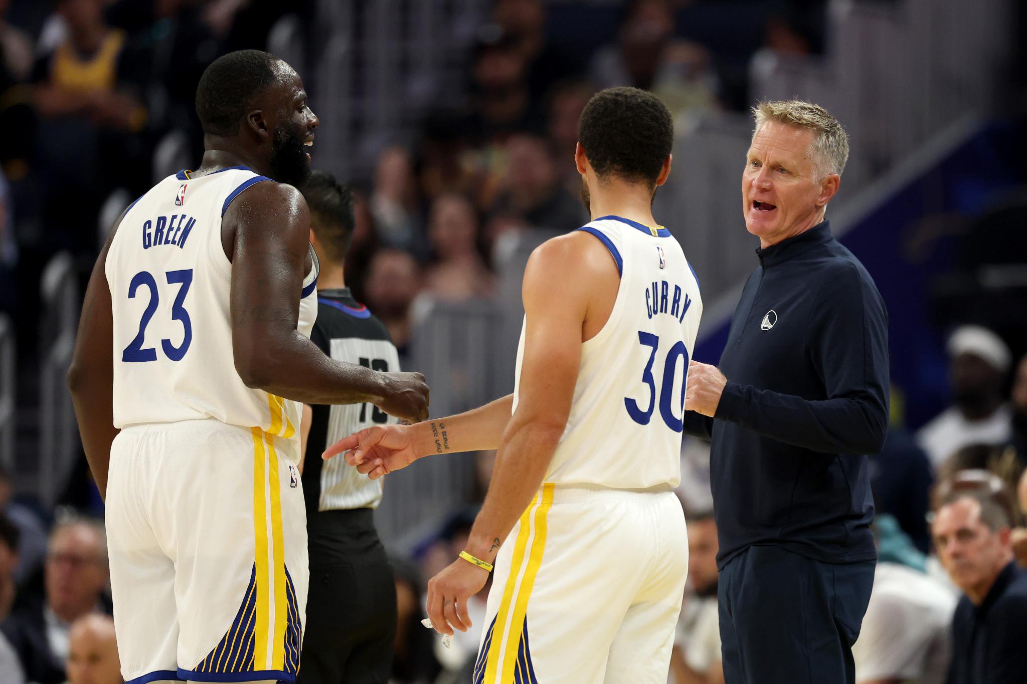 Golden State Warriors head coach Steve Kerr talks to Draymond Green and Stephen Curry during a game against the Portland Trail Blazers.