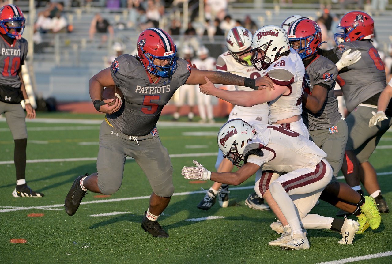Old Mill Patriots Jakhai Spano #5 gives a stiff arm to Broadneck Bruins Cameron Rawlinson #28 and runs by Dominic Montgomery #6 for decent yards in the second quarter. The Old Mill Patriots host the visiting Broadneck Bruins in high school football at the Severn Run High School. (Paul W. Gillespie/Staff)