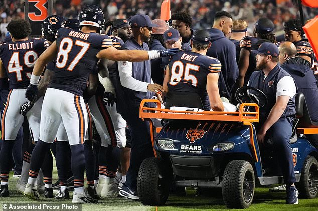 Chicago Bears' Sam Roush (87) reaches out to Cole Kmet (85) as he is carted off the field after suffering an injury on a pass play during the second half of an NFL football game against the New England Patriots in Chicago, Thursday, Oct. 22, 2026. (AP Photo/Nam Y. Huh)