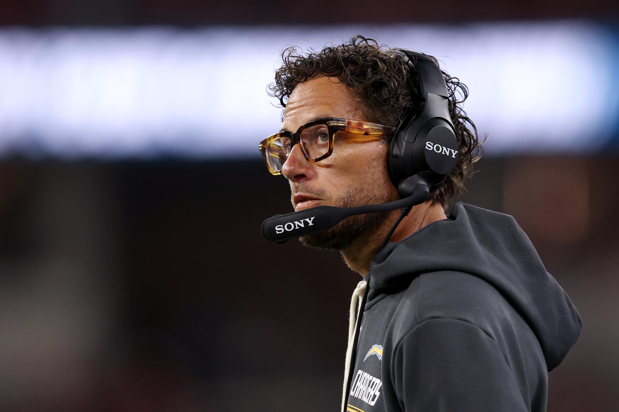 Offensive coordinator Mike McDaniel of the Los Angeles Chargers on the sidelines wearing a headset during a game against the San Francisco 49ers.
