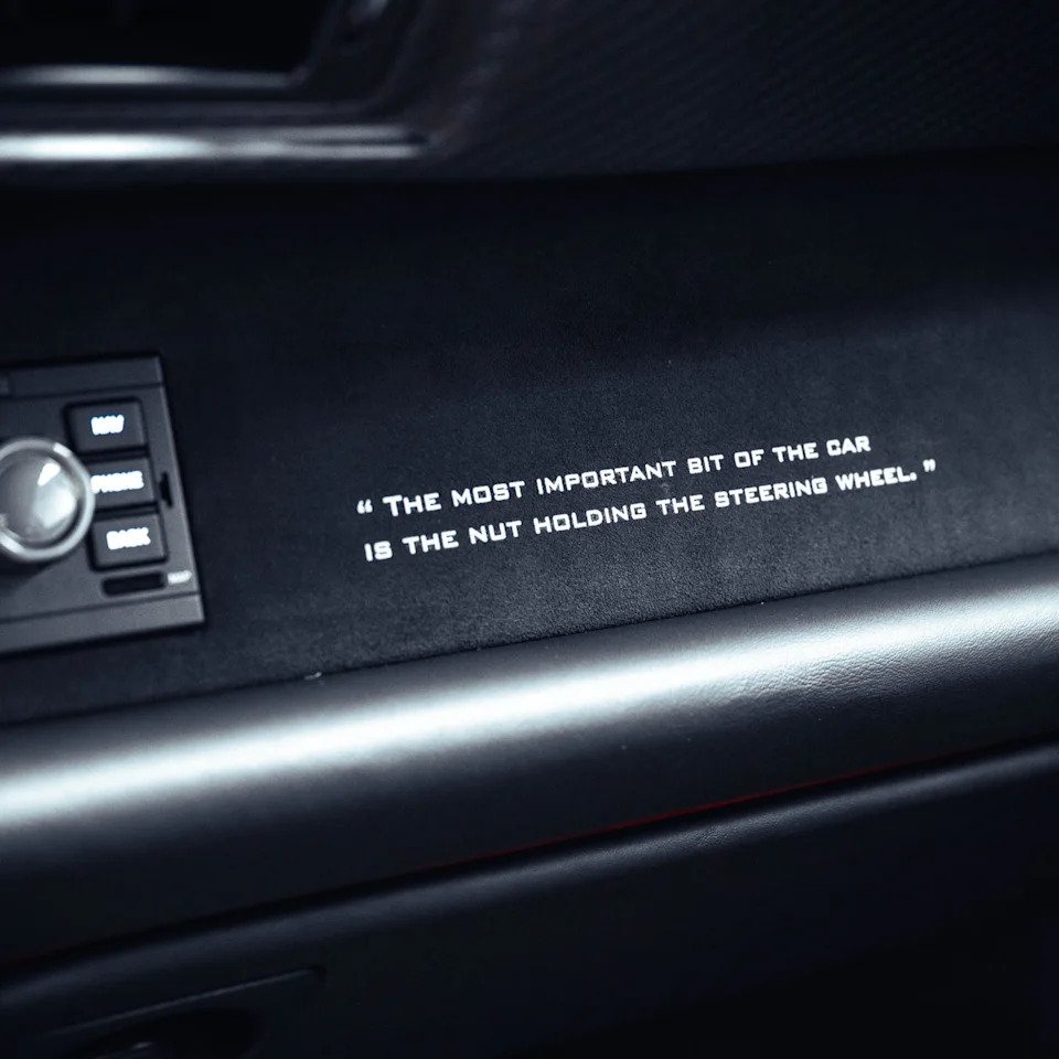 Quote on a car's dashboard: "The most important bit of the car is the nut holding the steering wheel.
