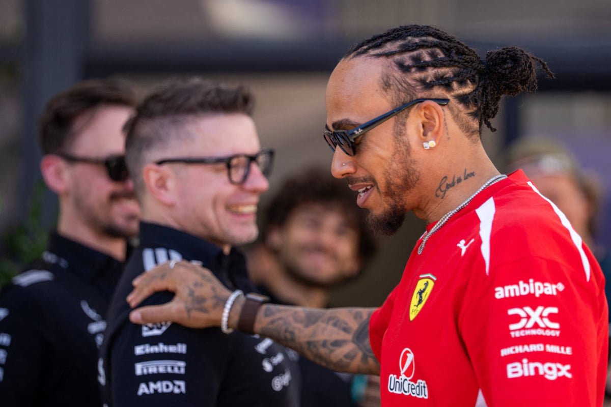 Hamilton walking past Bono touching his shoulder with a smile at the Chinese GP — Photo: © IMAGO