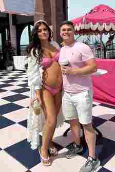 pregnant woman in bikini standing next to husband