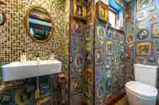 Another bathroom with bold wallpaper and gold accents