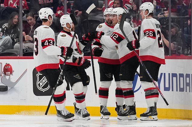Ottawa Senators' Shane Pinto (12), second from right, celebrates his goal with teammates during the second period of an NHL hockey game against the New Jersey Devils in Newark, N.J., Monday, Oct. 12, 2026. (AP Photo/Seth Wenig)
