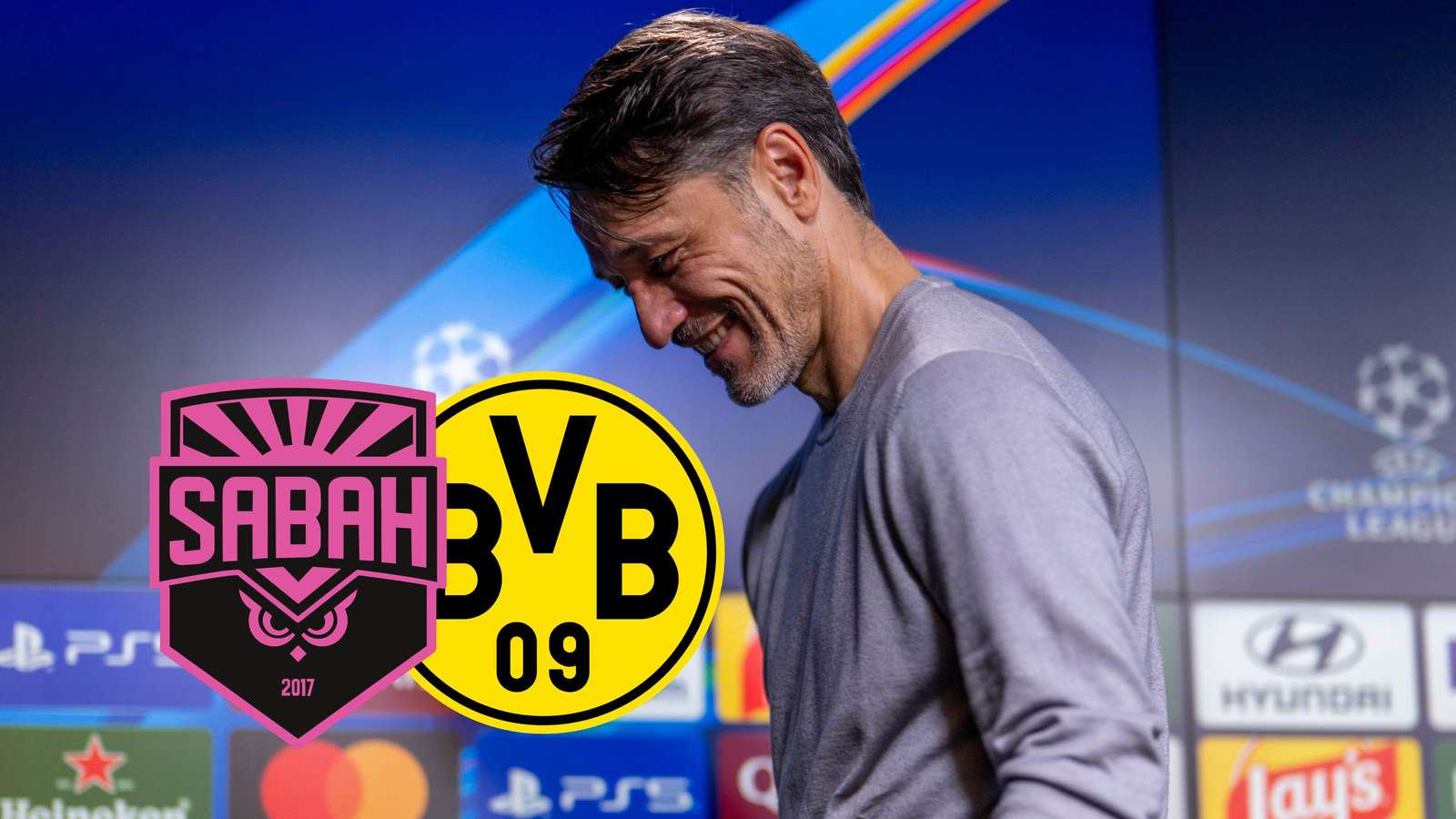 Niko Kovac auf einer CL-Pressekonferenz neben dem Sabah- und BVB-Wappen.