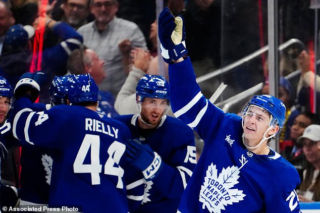 Toronto Maple Leafs' Troy Stecher, right, celebrates after his goal against the New York Rangers during the third period of an NHL hockey game in Toronto, Thursday, Oct. 22, 2026. (Frank Gunn/The Canadian Press via AP)