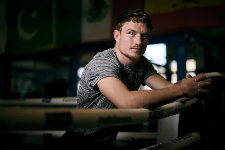 Junior welterweight Dalton Smith leans over the ropes of a boxing ring.